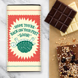 Chocolate Bar with yellow, red and green design with upside tortoise and the wording 'Hope you're back on your feet soon'