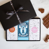 Three chocolate bars in a sleek black gift box tied by a Quirky-branded ribbon 