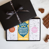 Three chocolate bars in a sleek black gift box tied by a Quirky-branded ribbon 