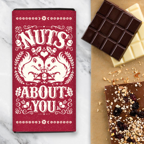 Chocolate Bar with Red Wrapper Design and an illustration of two squirrels sharing a nut romantically and the wording 'Nuts About You'