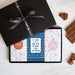 Three chocolate bars in a sleek black gift box tied by a Quirky-branded ribbon 