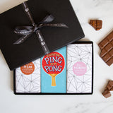 Three chocolate bars in a sleek black gift box tied by a Quirky-branded ribbon 