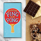 A chocolate bar with a blue wrapper design and red ping pong bat with the wording 'You Put The Ping In My Pong'